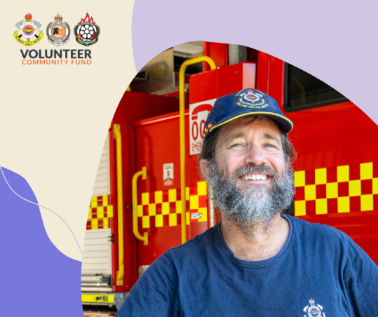 Brad George, NT Fire and Rescue volunteer - Brad is wearing the blue NTFRS uniform and cap and is standing in front of a fire truck